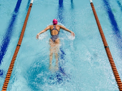 Woman swimming in a gym pool in Speedo swimwear