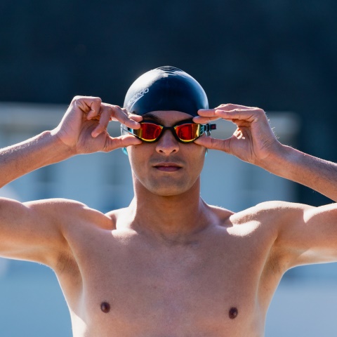 Lady putting on her Speedo swimming goggles and wearing a Speedo swimsuit