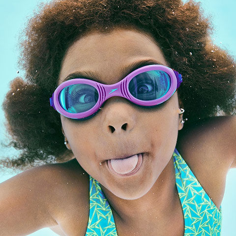 Kid swimming under water with her Speedo swimsuit and swimming goggle