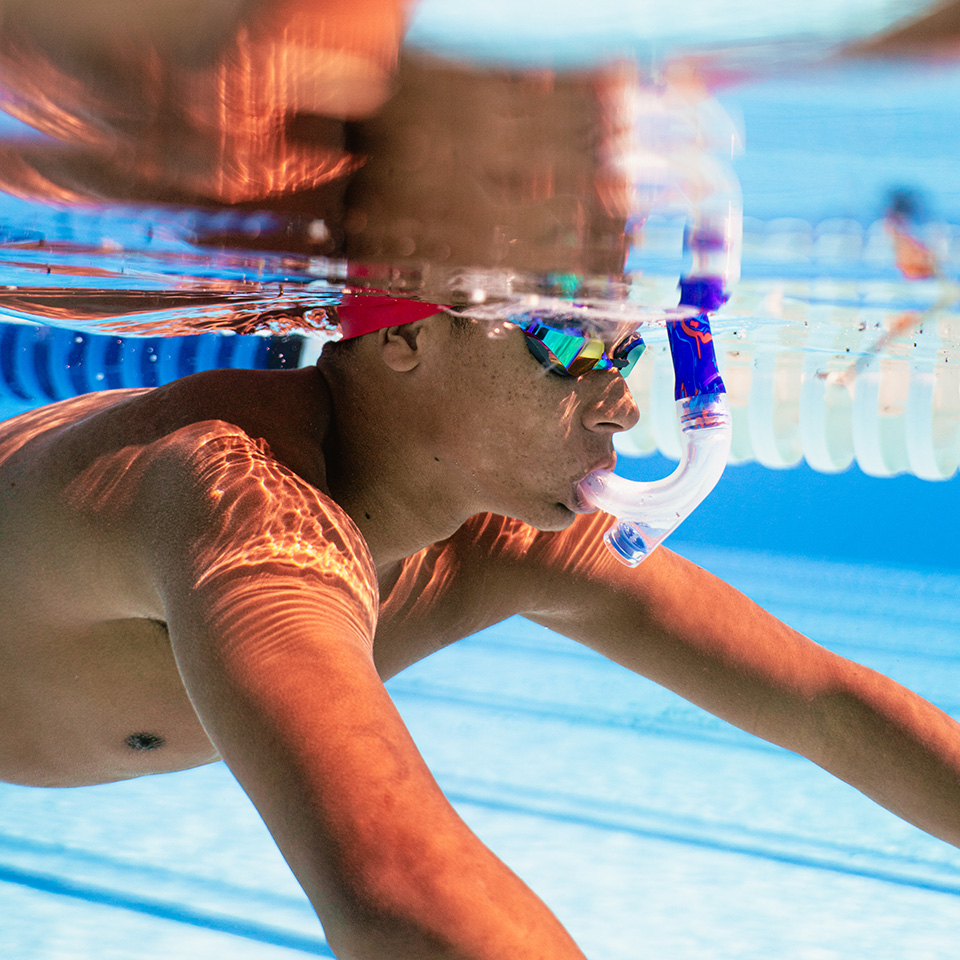 boy swimming in Speedo swimwear and snorkel